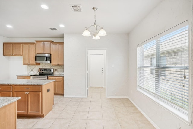 kitchen featuring pendant lighting, appliances with stainless steel finishes, light stone counters, tasteful backsplash, and a chandelier