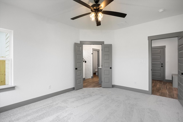 unfurnished bedroom featuring ceiling fan and dark carpet