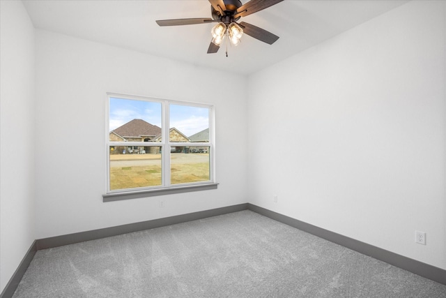 carpeted spare room featuring ceiling fan