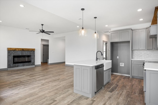 kitchen with hanging light fixtures, dishwasher, sink, and gray cabinetry