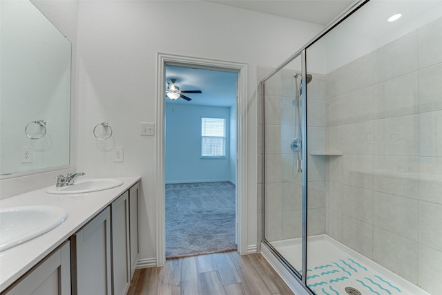 bathroom with hardwood / wood-style flooring, a shower with shower door, and vanity