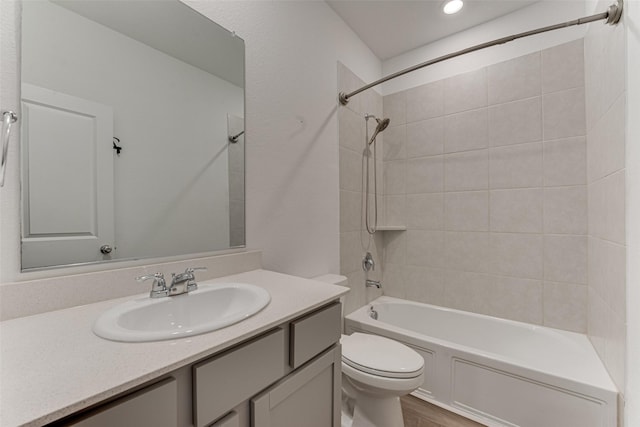 full bathroom with tiled shower / bath combo, vanity, and toilet