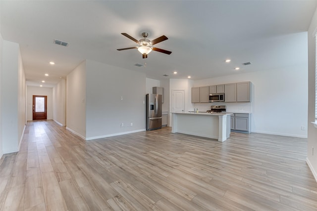 unfurnished living room with light wood-type flooring and ceiling fan