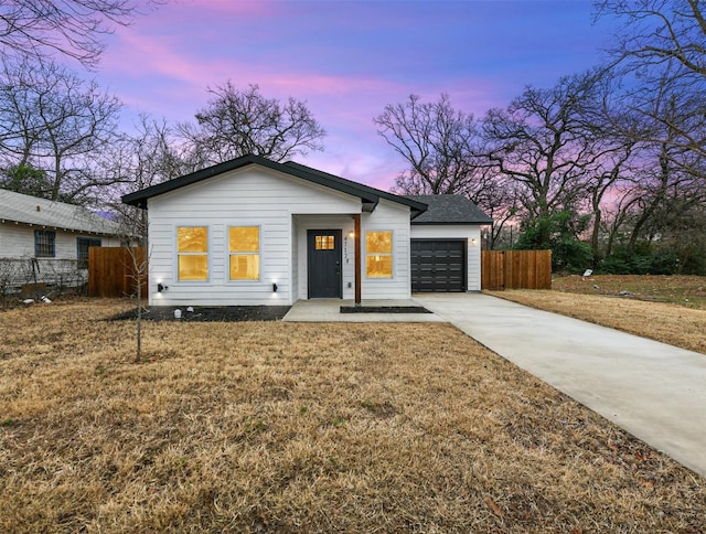 view of front of home featuring a garage and a yard