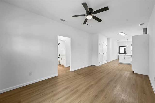 unfurnished living room featuring ceiling fan and light wood-type flooring