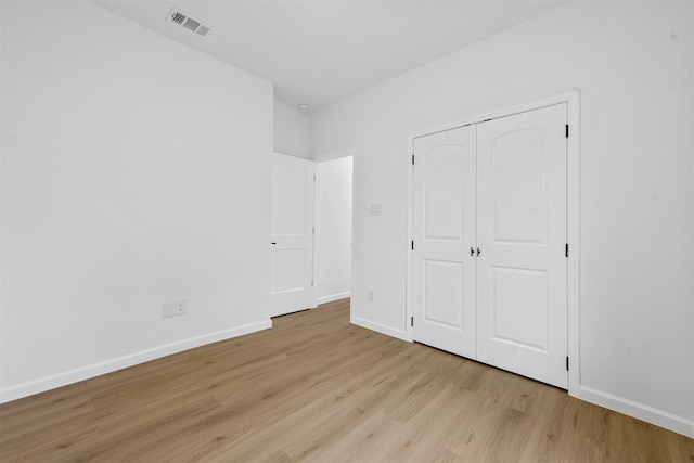 unfurnished bedroom featuring light hardwood / wood-style flooring and a closet