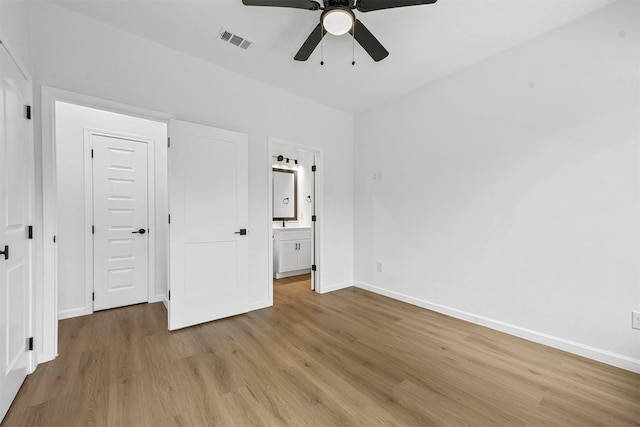 unfurnished bedroom featuring ensuite bathroom, ceiling fan, and light hardwood / wood-style flooring