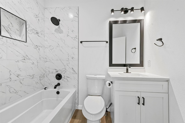 full bathroom featuring hardwood / wood-style flooring, tiled shower / bath, vanity, and toilet