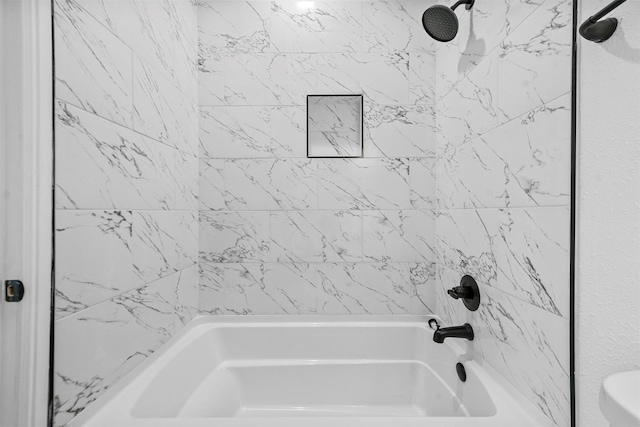 bathroom featuring tiled shower / bath