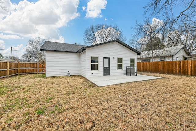 rear view of house with a lawn and a patio