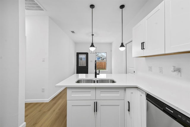 kitchen featuring sink, white cabinetry, dishwasher, kitchen peninsula, and pendant lighting