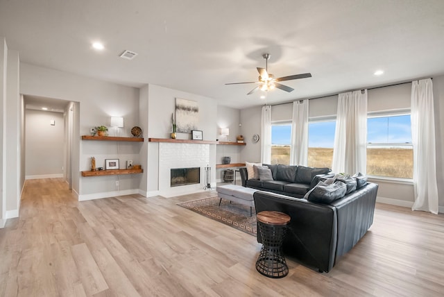 living area featuring a fireplace, recessed lighting, light wood-style flooring, ceiling fan, and baseboards