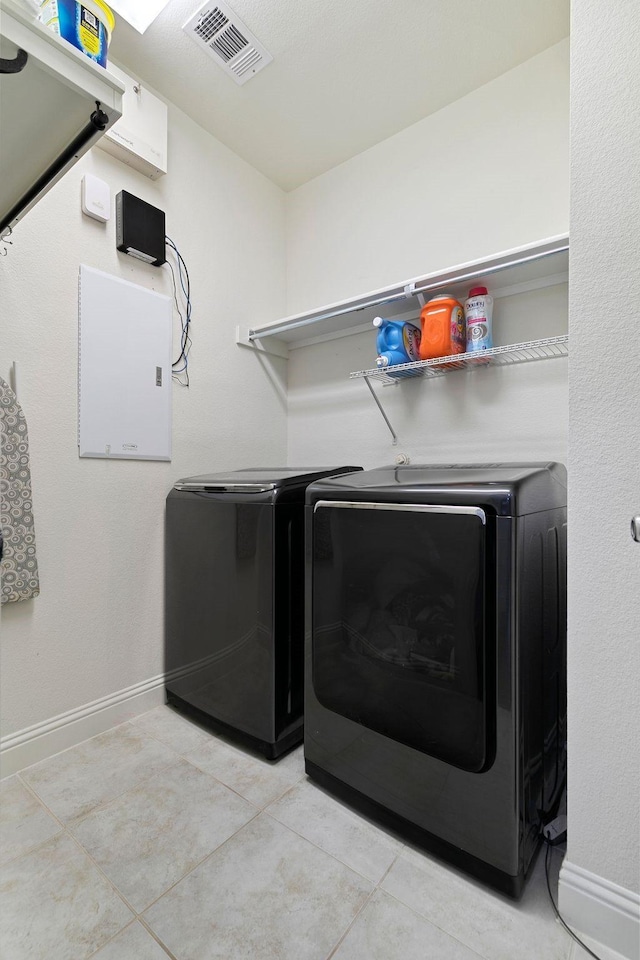 laundry room with light tile patterned floors and washer and clothes dryer