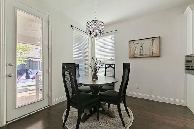 dining space with dark hardwood / wood-style flooring and a notable chandelier