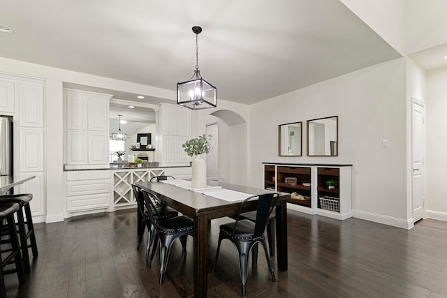 dining area featuring dark wood-type flooring and a notable chandelier