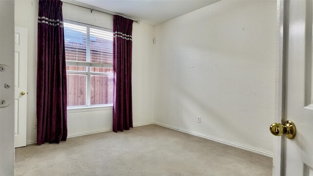 unfurnished room featuring light colored carpet