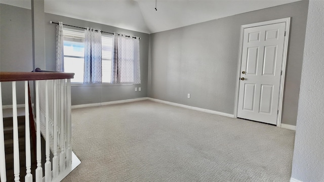 spare room featuring lofted ceiling and light carpet