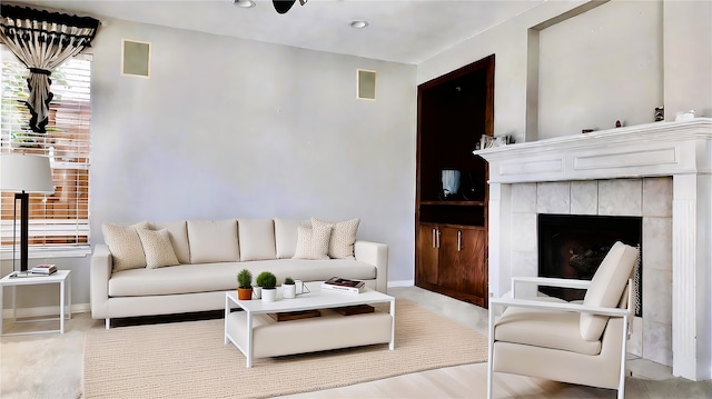 living room featuring a tiled fireplace