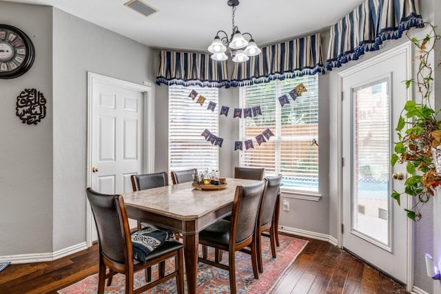 dining space featuring an inviting chandelier and dark hardwood / wood-style flooring