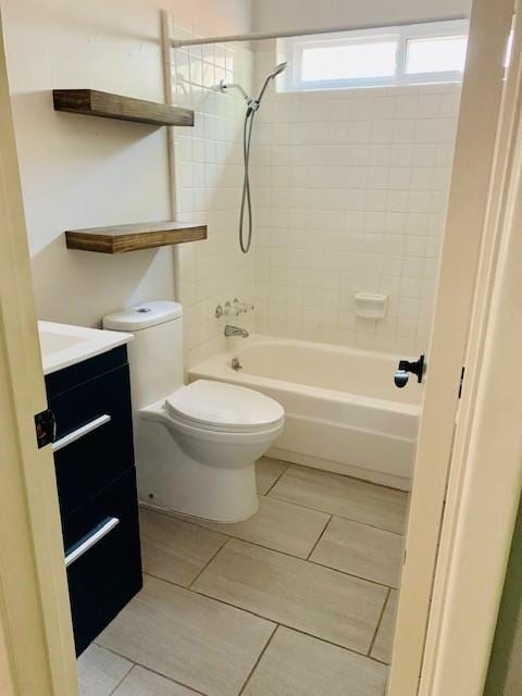 full bathroom featuring vanity, tiled shower / bath combo, and toilet