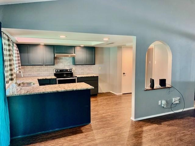 kitchen featuring wood-type flooring, sink, backsplash, light stone counters, and stainless steel electric range