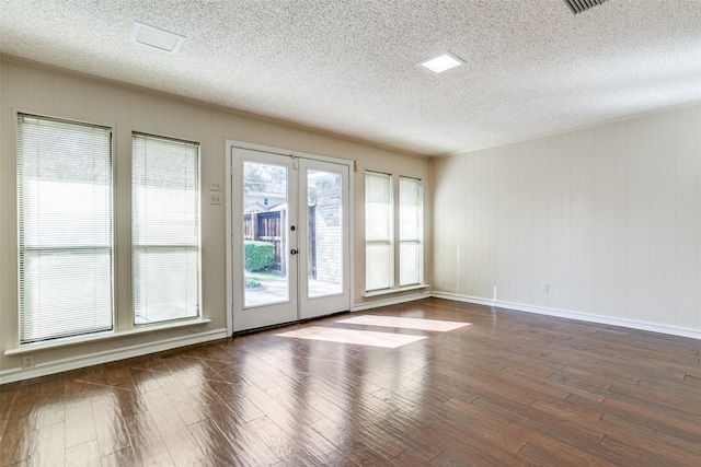 spare room with french doors, dark hardwood / wood-style flooring, and a textured ceiling