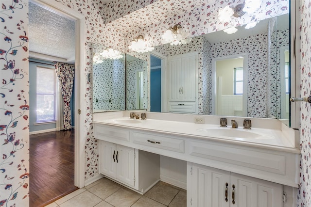 bathroom featuring a textured ceiling, tile patterned flooring, and vanity