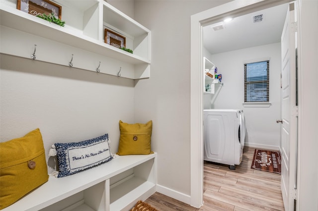 mudroom featuring washing machine and clothes dryer and light hardwood / wood-style flooring