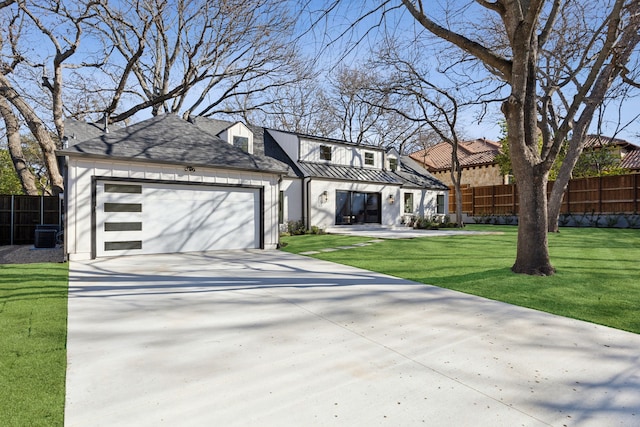 view of front facade featuring cooling unit, a garage, and a front yard