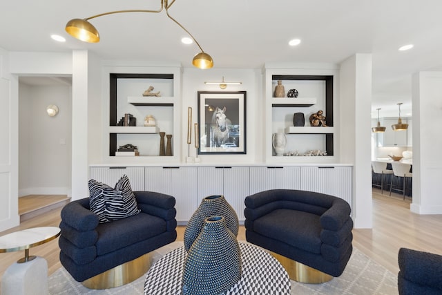 living room featuring built in features and light hardwood / wood-style floors