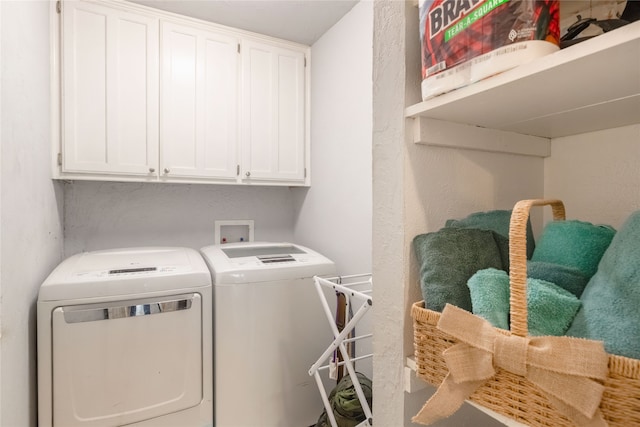 washroom featuring separate washer and dryer and cabinets