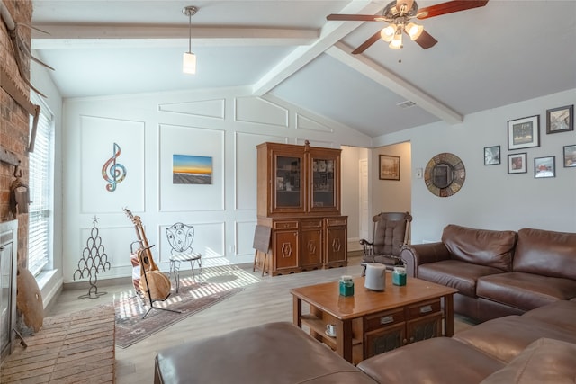 living room featuring a fireplace, lofted ceiling with beams, light hardwood / wood-style floors, and ceiling fan