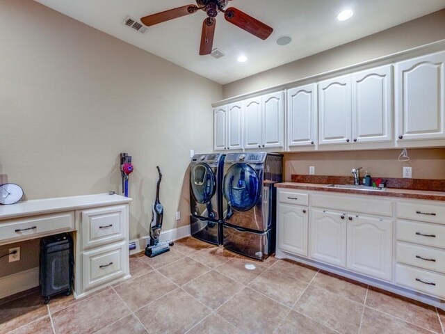 washroom featuring light tile patterned flooring, sink, cabinets, ceiling fan, and washing machine and dryer