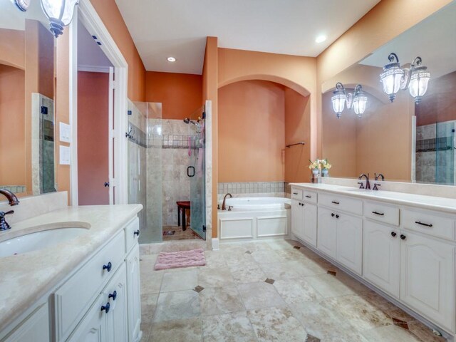 bathroom with vanity and shower with separate bathtub