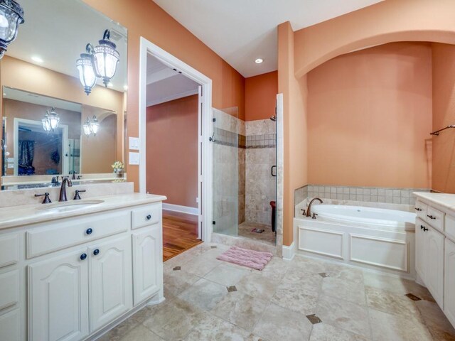 bathroom with vanity and shower with separate bathtub