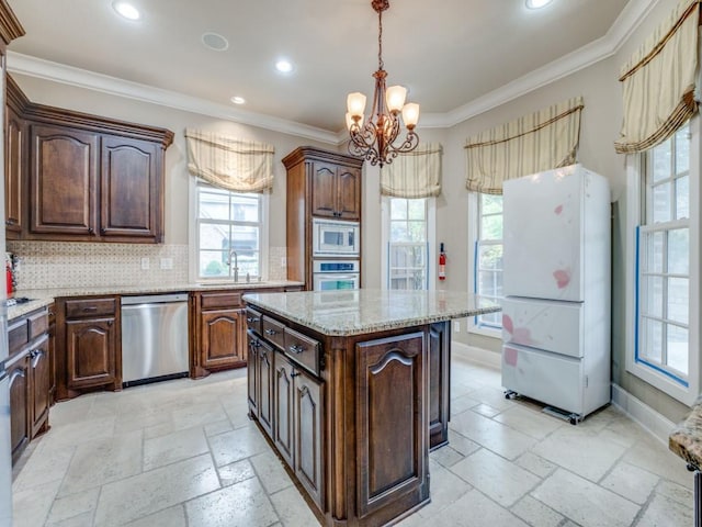 kitchen with sink, crown molding, appliances with stainless steel finishes, a kitchen island, and decorative backsplash