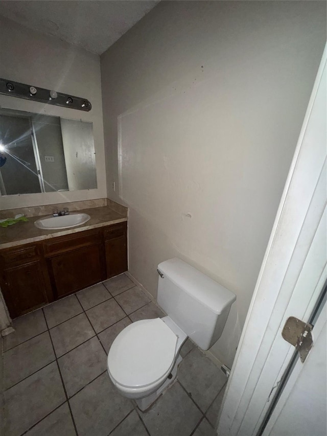 bathroom featuring vanity, tile patterned floors, and toilet