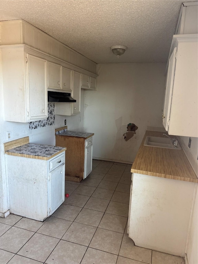 kitchen featuring light tile patterned flooring, sink, and a textured ceiling