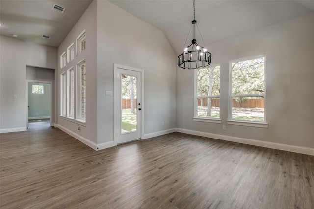 interior space featuring high vaulted ceiling, hardwood / wood-style floors, and a notable chandelier