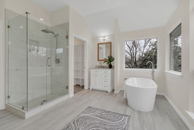 bathroom with vanity, lofted ceiling, and independent shower and bath