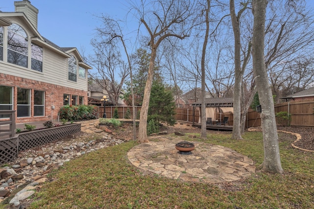 view of yard featuring an outdoor fire pit and a deck