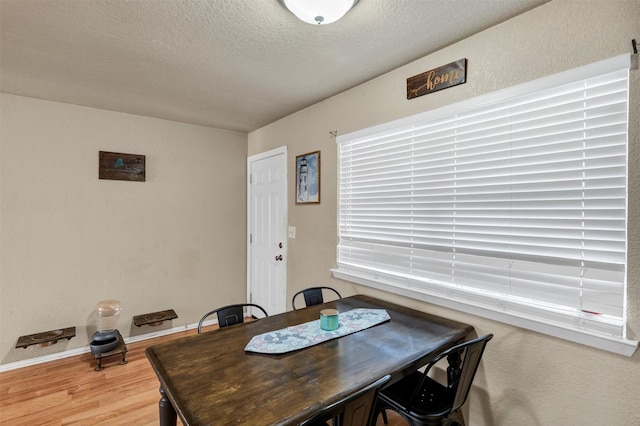 dining room with hardwood / wood-style flooring and a textured ceiling