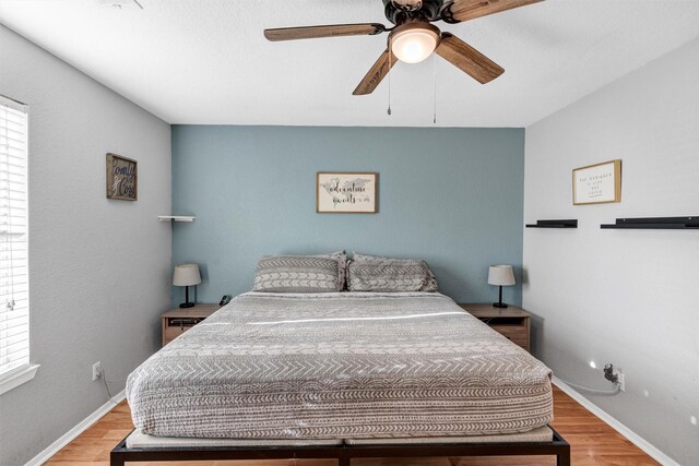 bedroom with ceiling fan and light hardwood / wood-style floors