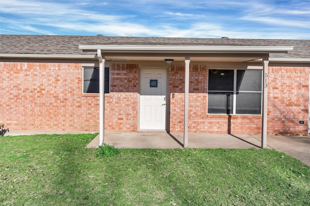 view of exterior entry featuring a yard