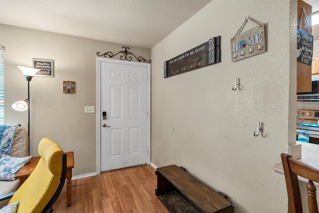 entrance foyer with light hardwood / wood-style floors and a textured ceiling