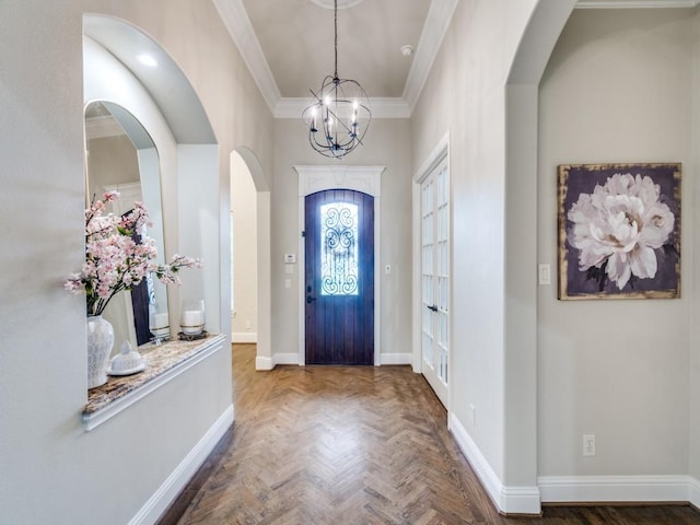 foyer entrance with crown molding, parquet flooring, and a notable chandelier