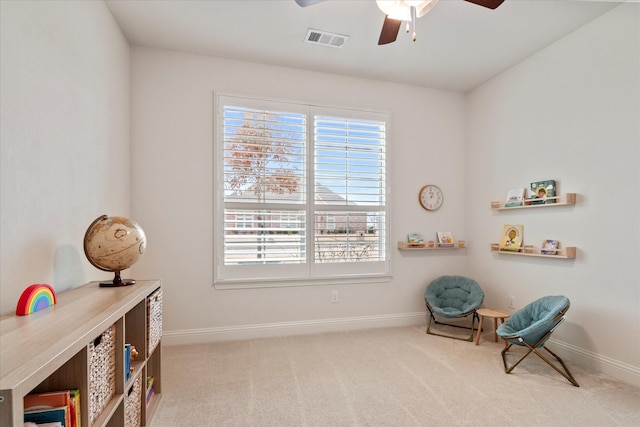 sitting room featuring light carpet and ceiling fan