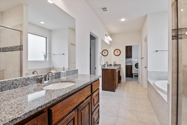 bathroom featuring vanity, tile patterned flooring, washer / dryer, and separate shower and tub