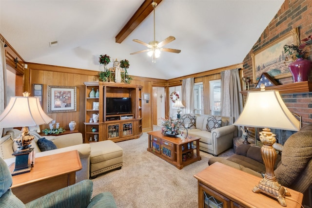 carpeted living room with wooden walls, lofted ceiling with beams, and ceiling fan