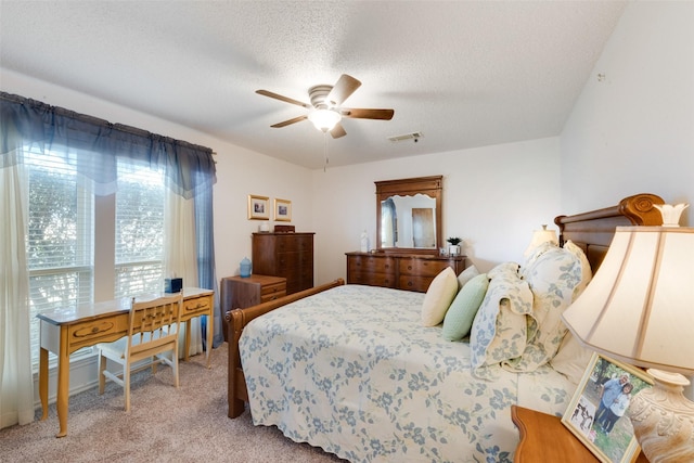 bedroom featuring ceiling fan, light colored carpet, and a textured ceiling